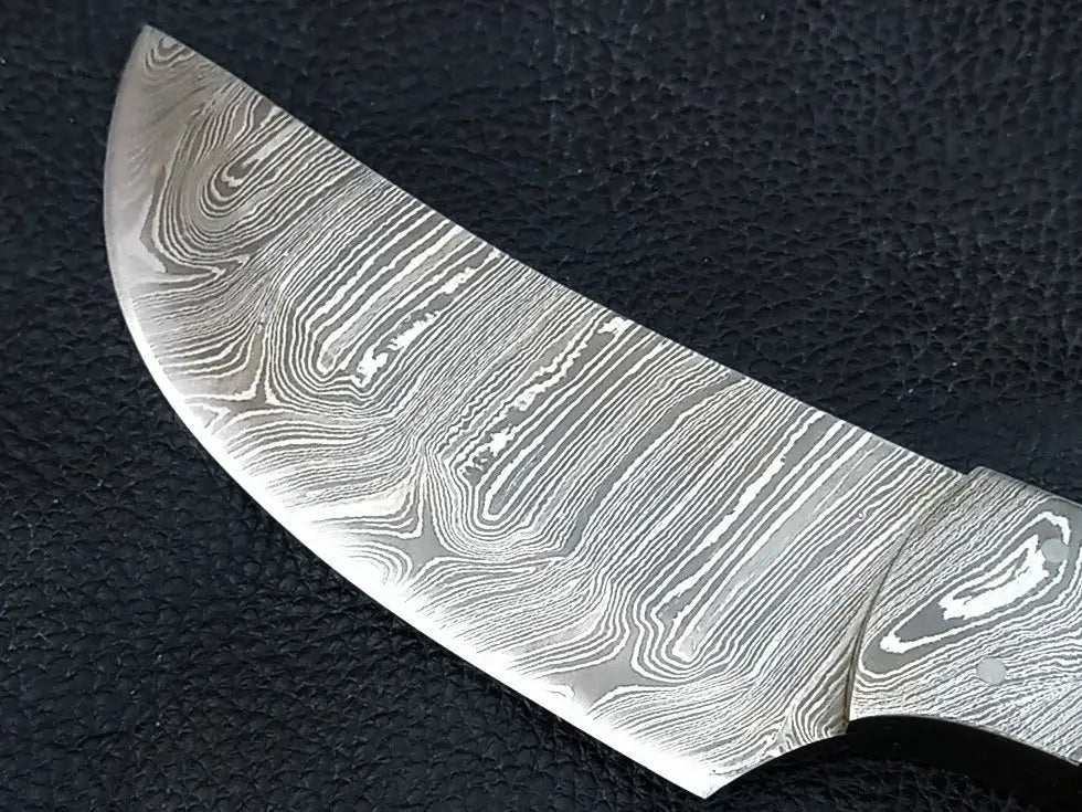 Handmade Damascus steel knife on black surface