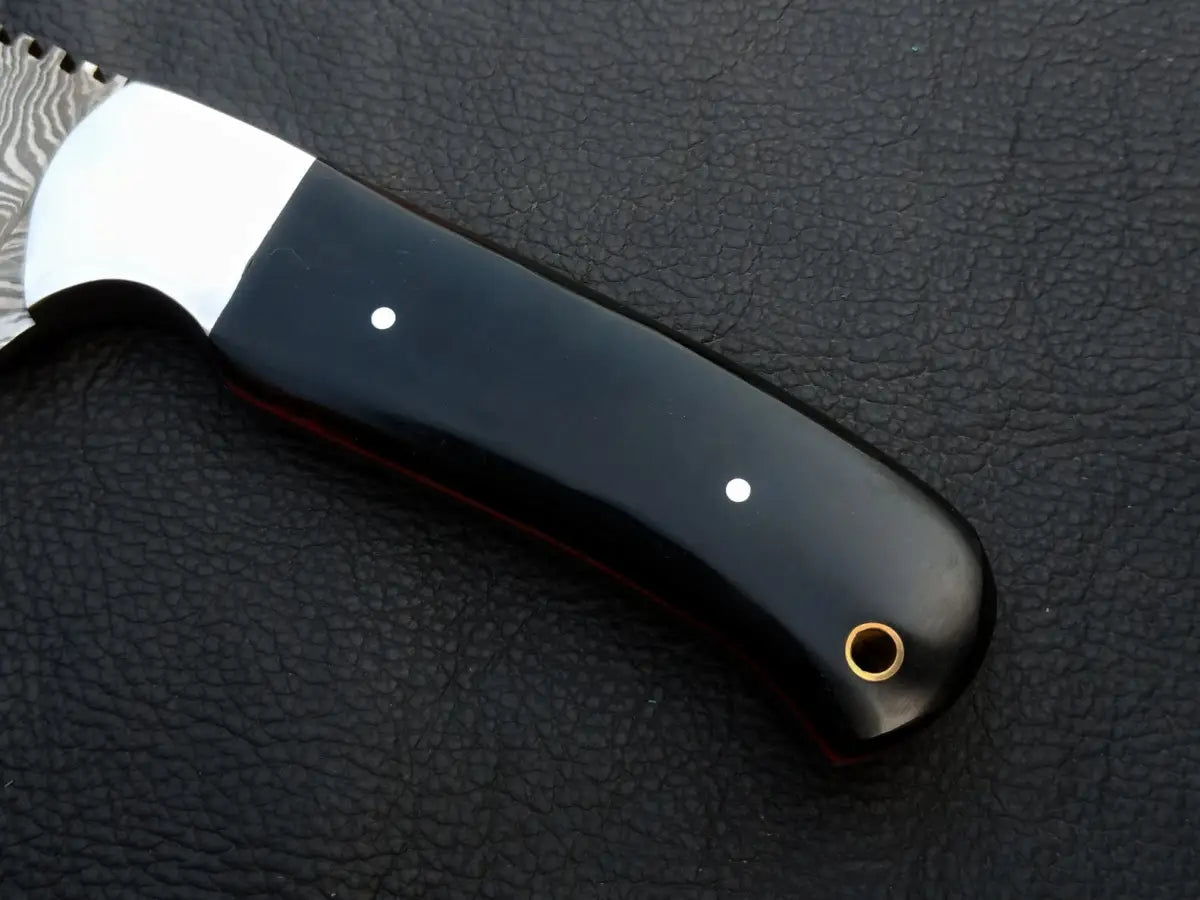 Handmade Damascus Steel Skinning Knife on Black Surface