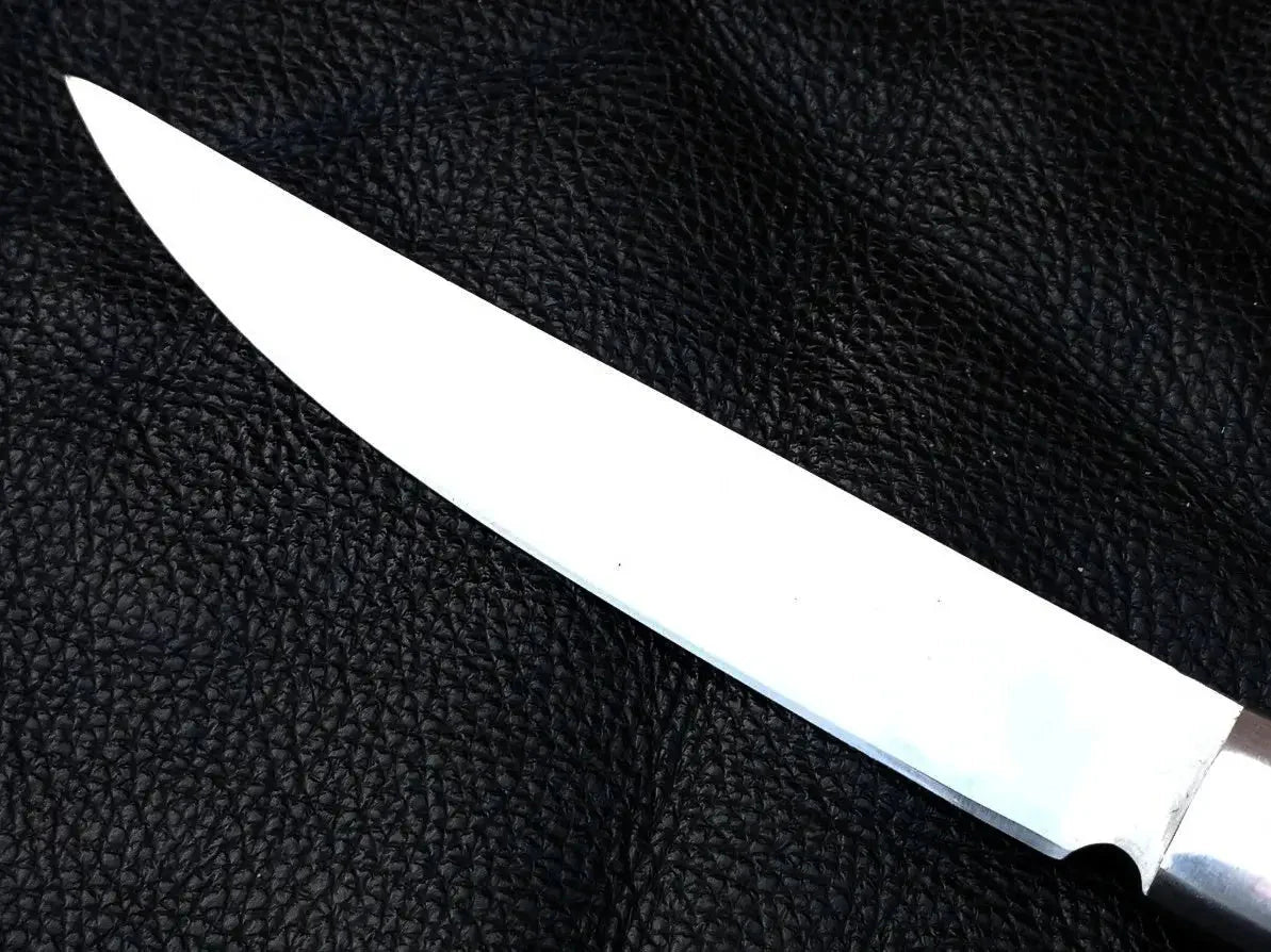 Damascus steel bird and trout knife on black leather background