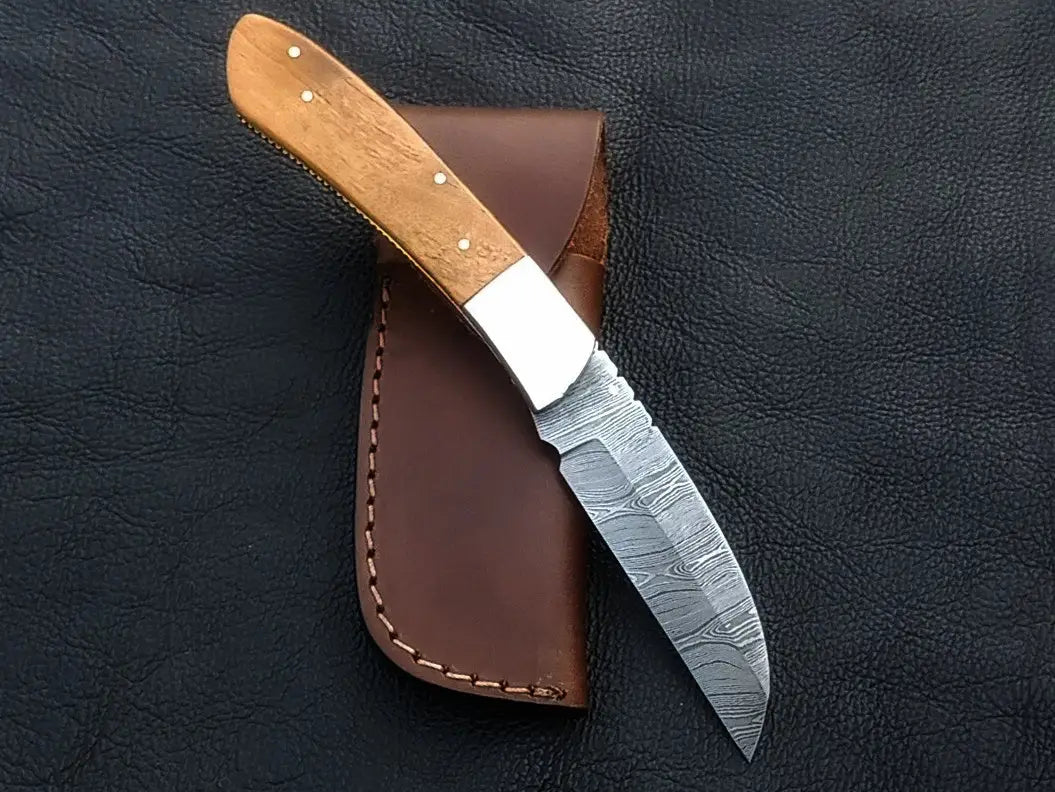 Handmade Damascus Steel Folding Knife C164 with leather sheath displayed elegantly