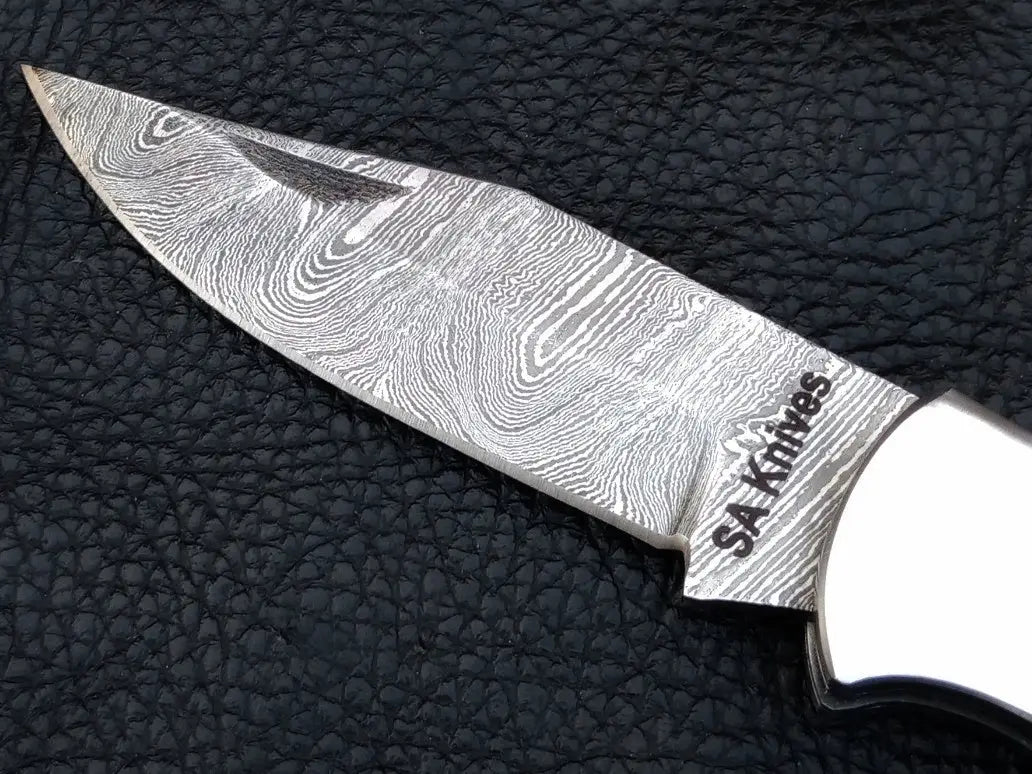 Handmade Damascus Steel Folding Knife-C89 on leather surface