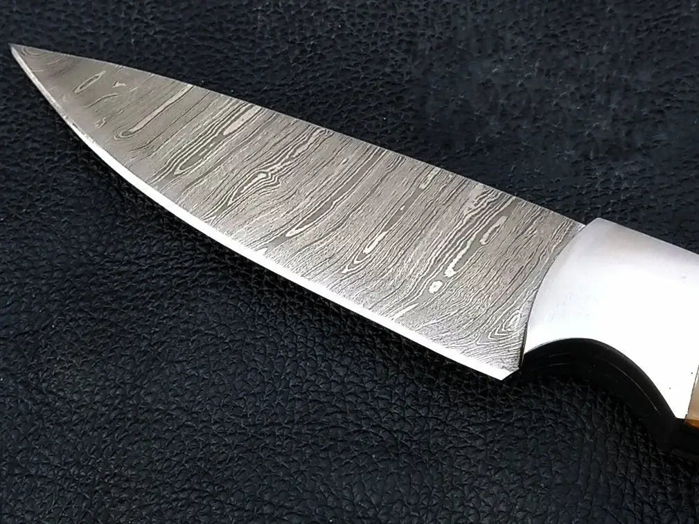 Handmade Damascus hunting knife with wooden handle on black background
