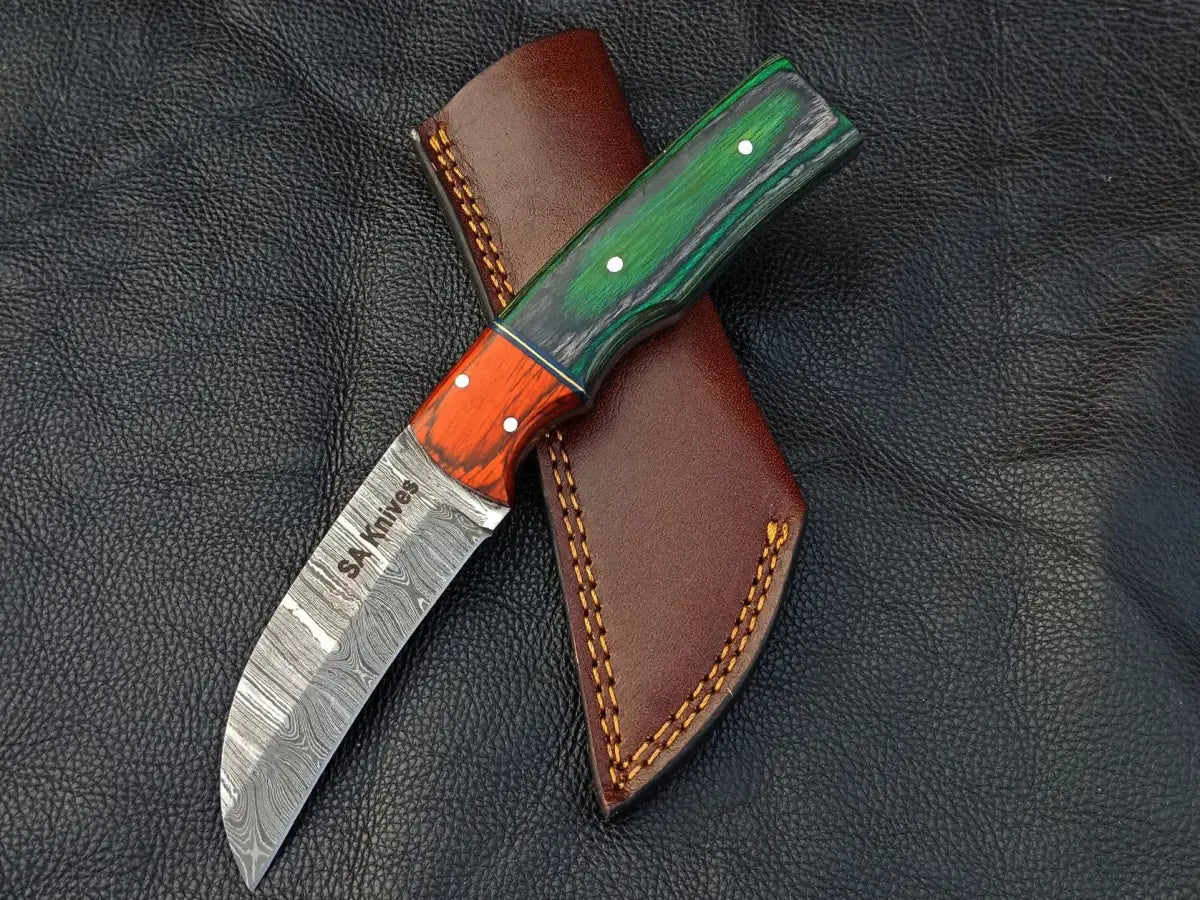 Damascus steel bolster skinning knife with green grey handle and orange bolster sheath