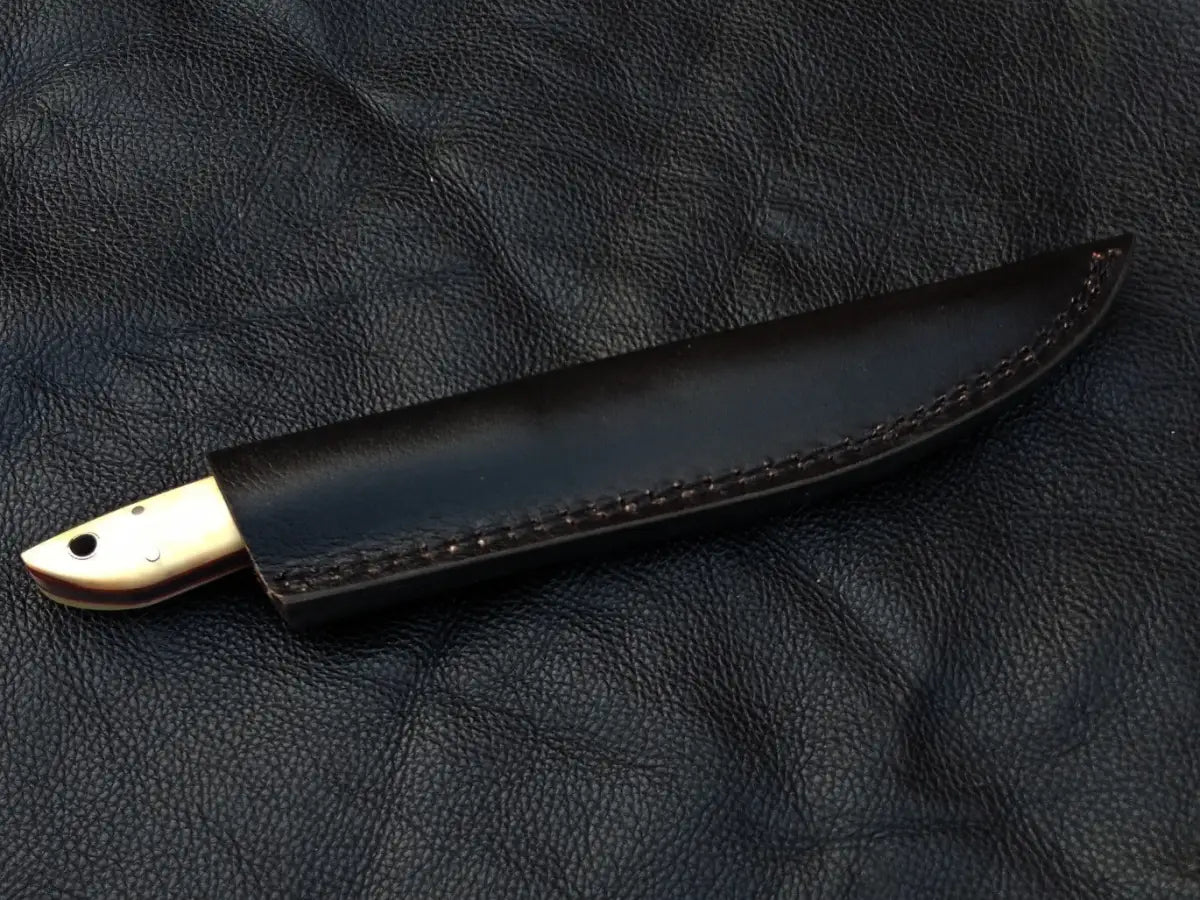 Damascus Steel Bird and Trout Knife on Black Leather Surface