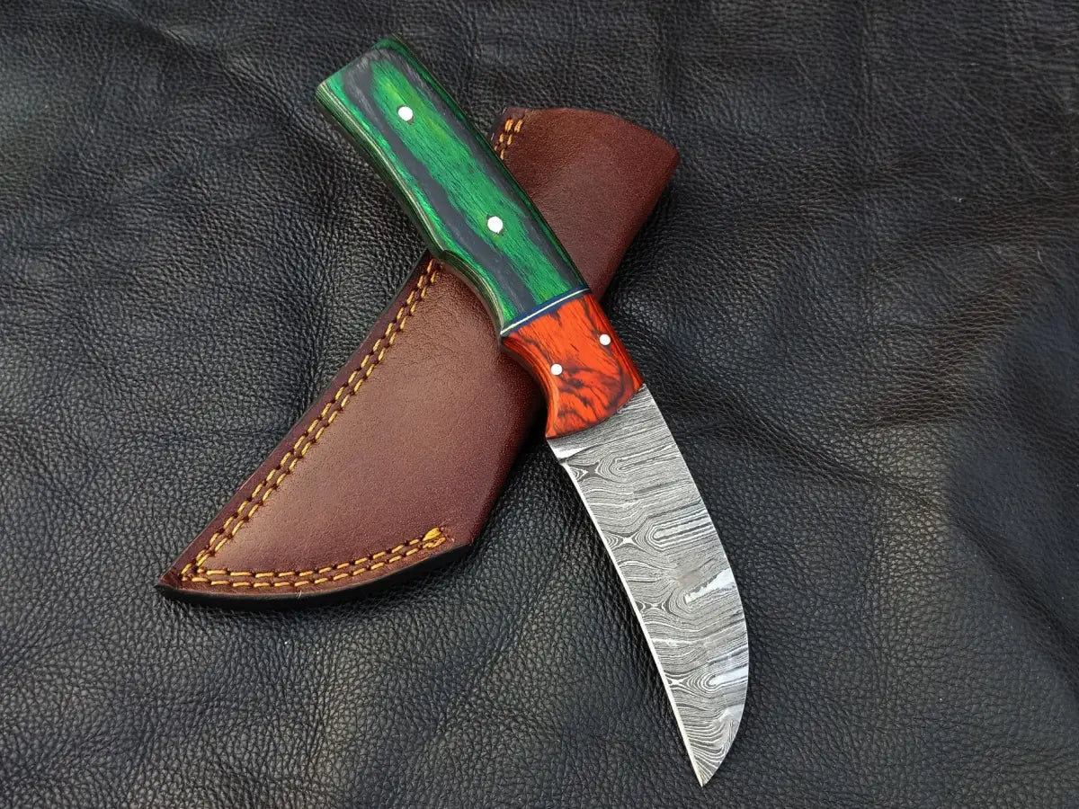 Damascus steel bolster skinning knife with green grey handle and orange bolster sheath