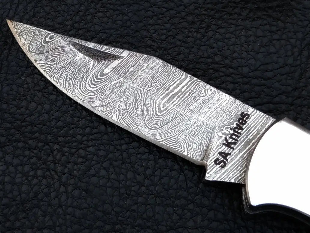 Handmade Damascus Steel Folding Knife-C86 on black leather surface