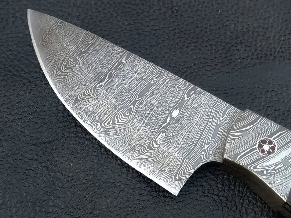 Close up of Damascus Steel Knife-C96 on black surface with red dot