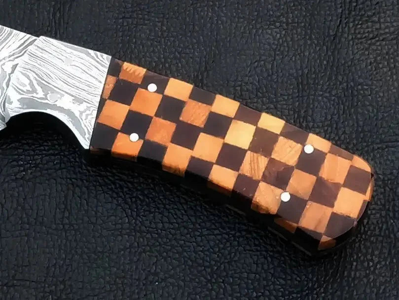 Damascus steel hunting knife with wooden handle on black background.