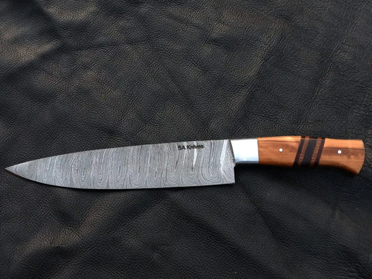 Handmade Damascus Steel Chef’s Knife with Wooden Handle on Leather Surface