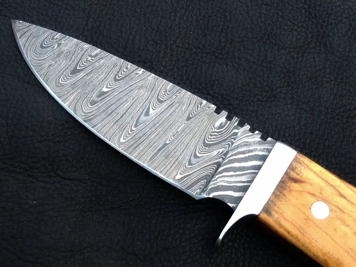 Handmade Damascus steel skinning knife on black surface